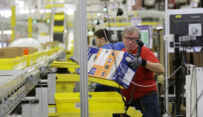 Mark Oldenburg processes outgoing orders at Amazon.com's fulfillment center in DuPont, Wash, in this Nov. 30, 2015, file photo. AP Photo/Ted S. Warren, File