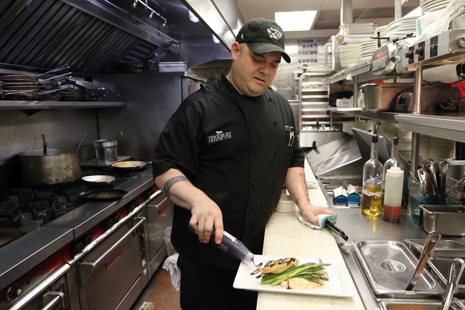 Tom Peracchi, executive chef at Tewksbury Country Club, finishes an order of chicken risotto. Wicked Local Staff Photo/Ann Ringwood