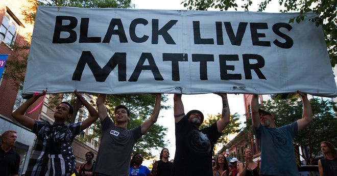 A Black Lives Matter rally is held at Bronson Park on Friday, July 22, 2016 in Kalamazoo, Mich. After the rally at Bronson Park, the movement preceded to shut down the Kalamazoo Mall by blocking the street and demanding change from Kalamazoo government officials and Kalamazoo Public Safety. (Bryan Bennett/Kalamazoo Gazette-MLive Media Group via AP)