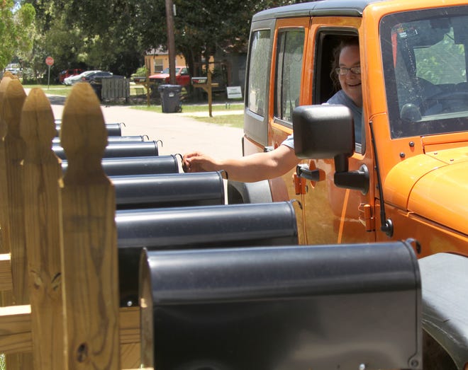 Mail carrier Kachina Starr delivers some mail recently to a row of new mailboxes on South Pine Street in Bunnell. NEWS-JOURNAL/DAVID TUCKER