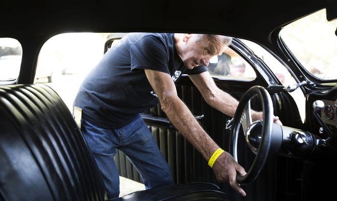 Allen Ferrell, of Springfield, Mo., lowers the steering wheel of his 1951 Mercury leadsled during the KKOA leadseld spectacular car show Friday in Oakdale Park.