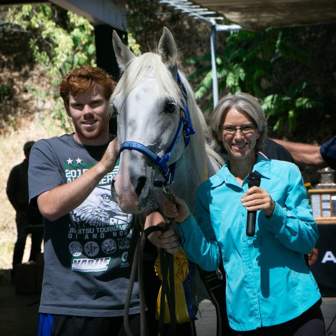 Former Marion resident and area OBGYN Dr. Karen Donley poses with her 14-year-old Arabian mare Royal Patron, and her son, JJ, who spent the first 85 miles of Donley's 100-mile Tevis Cup championship race at her side before being pulled due to the health of his horse. Donley became the 50th winner in the event's 61-year history. PHOTO COURTESY LYNNE GLAZER/WWW.LYNNEGLAZER.COM