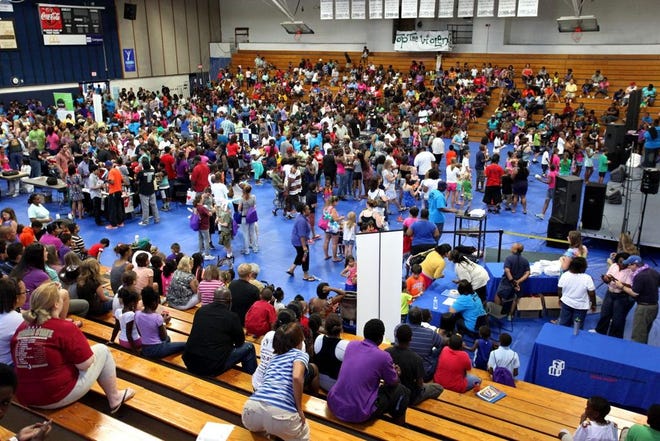 Thousands makes their way through tables at the 2013 Stop the Violence/Back to School Rally at the Santa Fe College gym. (File)