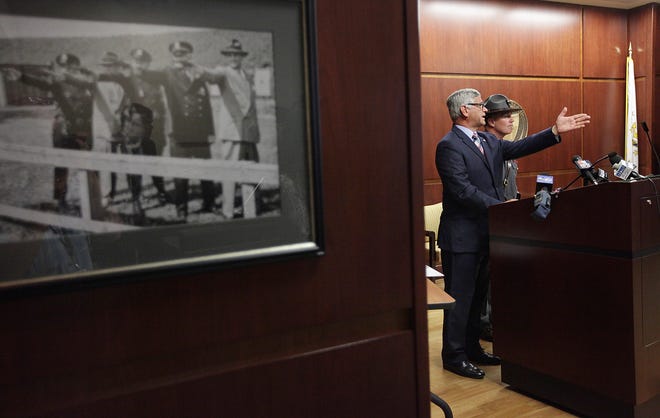 Attorney General Peter Kilmartin, left, speaks as state police Col. Steven G. O'Donnell listens during a news conference Friday, July 29, 2016, in Scituate, R.I. An investigation into former Boston Red Sox pitcher Curt Schilling's failed video game company, 38 Studios, has resulted in no criminal charges, authorities announced Friday.
