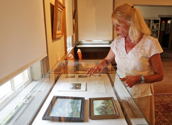 Ipswich Muesum curator Stephanie Gaskins looks over some of the memorabilia of Henry Rodman Kenyon in the exhibit at the Ipswich Museum. Wicked Local Staff Photo / Kirk R. Williamson