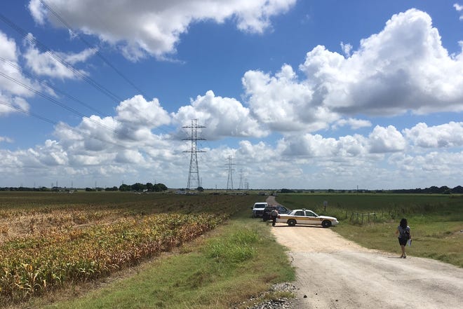 Police cars block access to the site where a hot air balloon crashed early Saturday near Lockhart, Texas. ASSOCIATED PRESS / JAMES VERTUNO