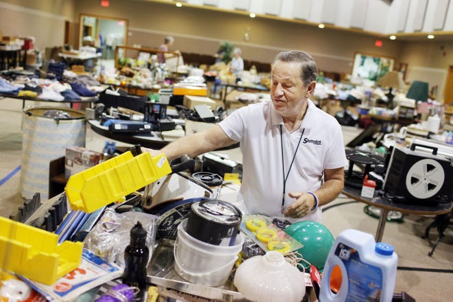 Dean Robinson sets up for the annual West Burlington Christian Church garage sale Friday at 545 Melville Avenue in West Burlington. The sale, which started Friday at 4 p.m., continues today from 7 a.m. to noon and coincides with West Burlington’s annual town-wide yard sales with from 8 a.m. to 4 p.m. today at more than 50 homes in West Burlington.