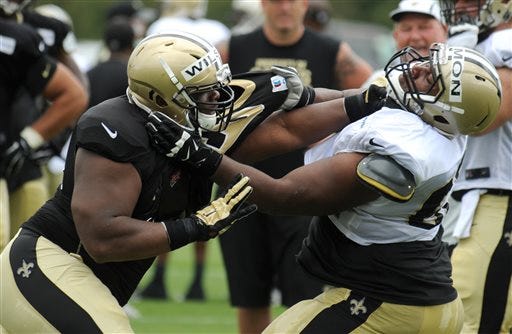 New Orleans Saints defensive linemen C.J. Wilson (69) and New Orleans Saints guard Cyril Lemon (62) in a blocking during the NFL football teams training camp in White Sulphur Springs, W.Va., Saturday, July 30, 2016. (AP Photo/Chris Tilley)