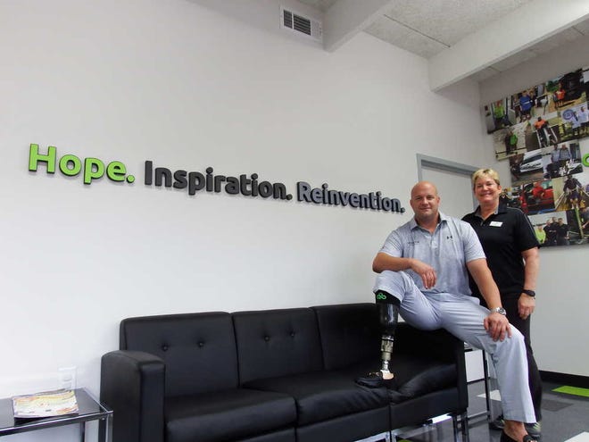 Joe Reisigl/Staff Steve Ehretsman, founder and CEO of Shamrock Prosthetics, and Sharon Kelly, prosthetist and clinician for the company, pose next to the business' motto, "Hope. Inspiration. Reinvention." Ehretsman, a right leg amputee, says the Athens-based business helps amputees by instilling them with hope, inspiring them and helping them reinvent their future.