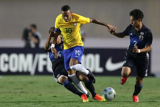 Brazil's Neymar, center, fight for the ball with Japan's Sei Maroya, right, and Japan's Yosuke Ideguche, left, during the friendly soccer game against Japan in preparation for the Olympics games, in Goiania, Brazil, Saturday, July, 30, 2016. (AP Photo/Eraldo Peres)