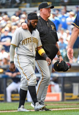 Pittsburgh Pirates' Josh Harrison, left, is helped off the field by manager Clint Hurdle, right, after a collision with Milwaukee Brewers' Keon Broxton during the sixth inning of a baseball game Sunday, July 31, 2016, in Milwaukee. (AP Photo/Benny Sieu)