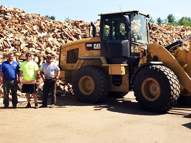 Dwarfed by a pile of firewood are, from left, Chad Knowles, Rob Wilich, and Robert Proulx. Courtesty photo/Ben Brady