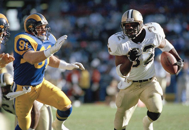 New Orleans Saints running back Vaughn Dunbar (32) runs away from Los Angeles Rams defender Kevin Greene during second quarter action at Anaheim Stadium, Dec. 14, 1992. Dunbar led all rushers with 91 yards on 13 carries in leading the playoff-bound Saints to a 37-14 win. (AP Photo/Craig Fujii)