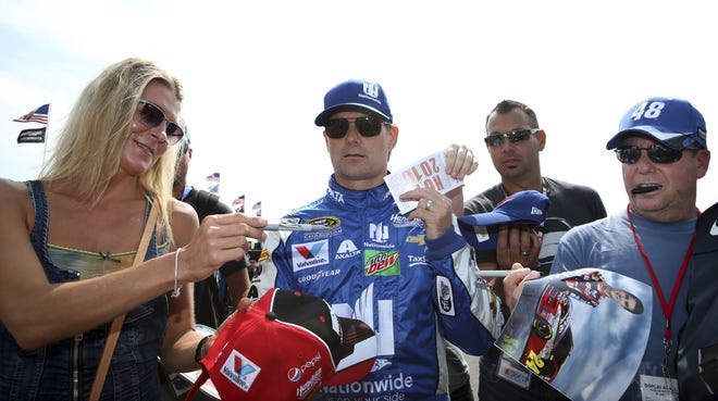 Jeff Gordon signs autographs for fans Saturday as he walks in the garage area at Pocono Raceway during practice for the Sprint Cup Series Pennsylvania 400 auto race in Long Pond, Pa. Associated Press/Mel Evans