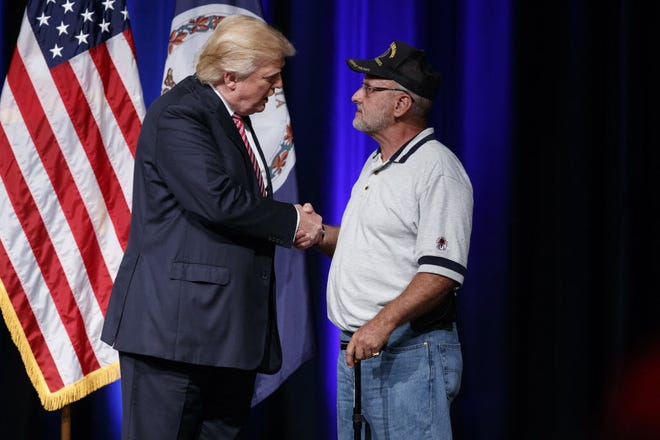 Republican presidential candidate Donald Trump shakes hands with Louis Dorfman, after Dorfman gave him his Purple Heart medal, during a campaign rally at Briar Woods High School, Tuesday, in Ashburn, Va. AP Photo/Evan Vucci