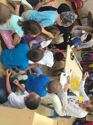 Reading Pals program volunteer engages children through books at Otis A. Mason Elementary School.
