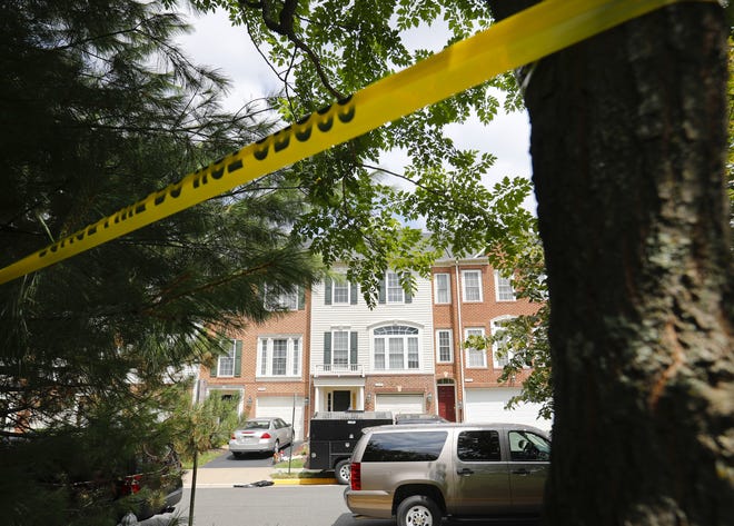 Law enforcement vehicles are parked outside the home of Nicholas Young, a Washington Metro Transit Officer, Wednesday, Aug. 3, 2016, in Fairfax, Va., Young was arrested at Metro's headquarters in Washington, and charged with a single count of attempting to provided material support to a terrorist group. (AP Photo/Pablo Martinez Monsivais)