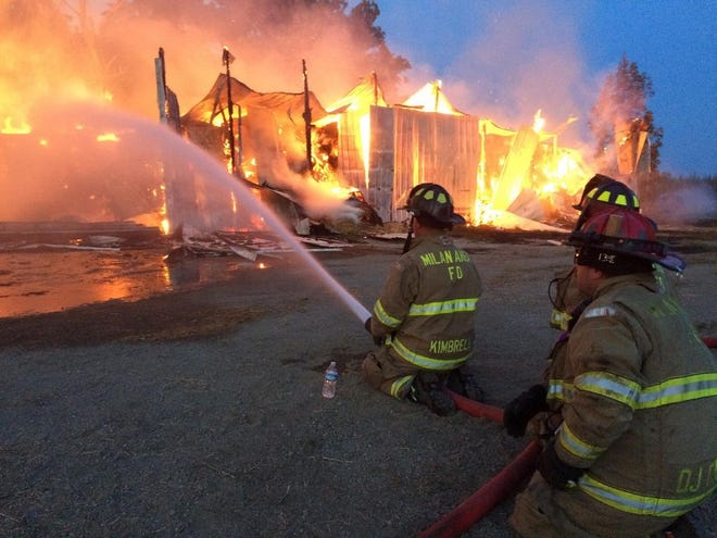 - Monroe News photo by RAY KISONAS
Crews battle a huge barn fire on Ann Arbor Rd. in Dundee Township. The barn was stocked with 30,000 bales of hay.
