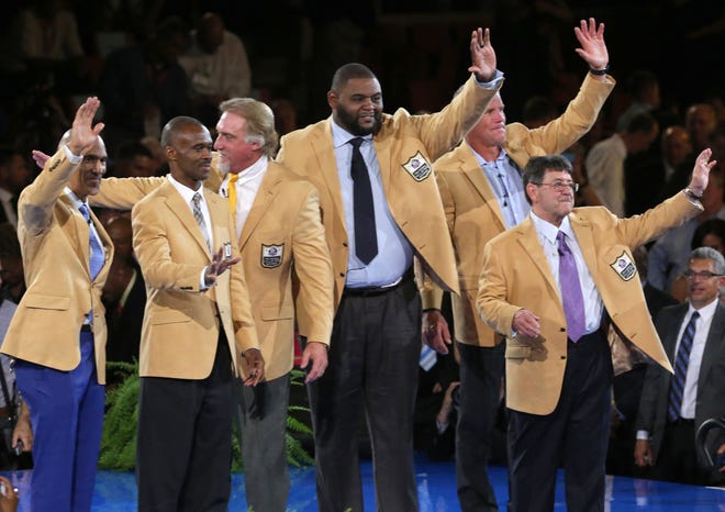 Members of the Pro Football Hall of Fame Class of 2016 wave to the crowd at the enshrinees' dinner, Thursday, Aug. 4, 2016, in Canton, Ohio, after receiving their gold jackets. From left are Tony Dungy, Marvin Harrison, Kevin Greene, Orlando Pace, Brett Favre, and Edward J. Debartolo, Jr. Not shown are representatives for the late Dick Stanfel and Ken Stabler. (Scott Heckel/The Repository via AP)