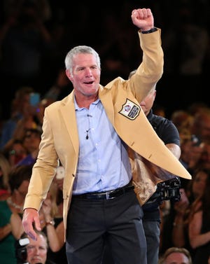 Brett Favre waves after receiving his gold jacket at the Pro Football Hall of Fame dinner on Thursday in Canton, Ohio. (Scott Heckel/The Canton Repository via AP)