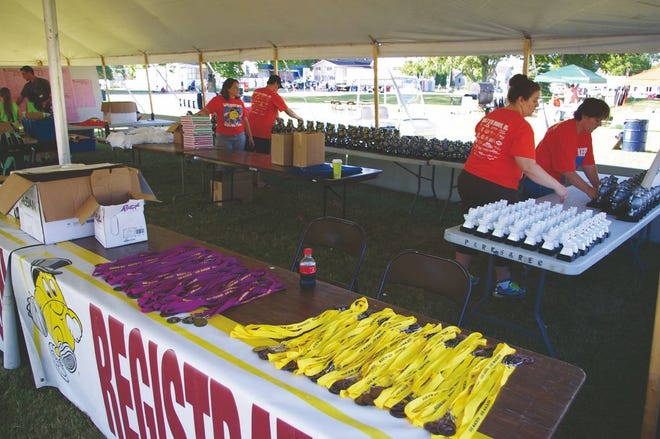 Volunteers pictured here preparing for the Gus Macker Basketball Tournament awards ceremony in July. Organizers say these important helpers were key to the event's success.