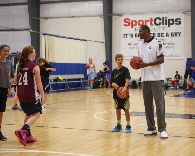 Walter McCarty, a former player and current assistant coach with the Boston Celtics, works with Case Poulin of New Castle at the A Step Ahead Basketball Camp on Friday at The Rim in Hampton. Matt Parker/Seacoastonline