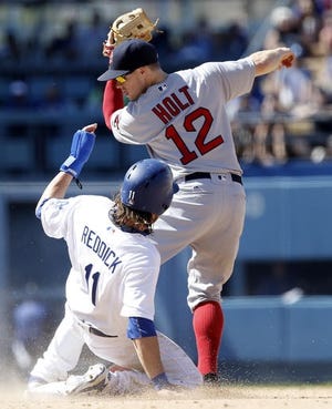 Red Sox second baseman Brock Holt (12) touches second base before Los Angeles Dodgers' Josh Reddick (11) slides into the bag for an out on a fielder's choice during the eighth inning of Saturday's game. AP Photo/Alex Gallardo