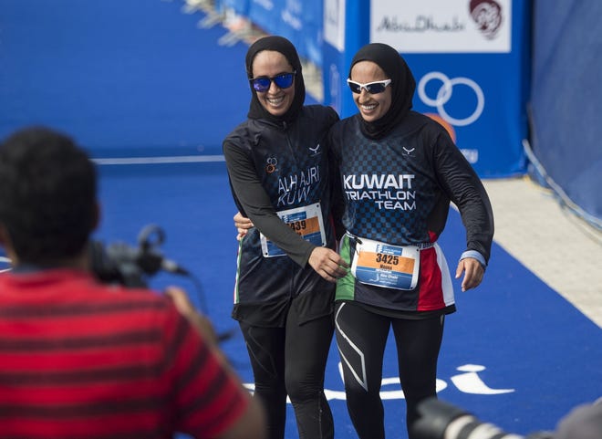 Nada Aljeraiwi, left, and Noura Al Hajeri share a laugh after completing in the ITU World Triathlon in Abu Dhabi, United Arab Emirates, earlier this year. Nikki Kahn/Washington Post