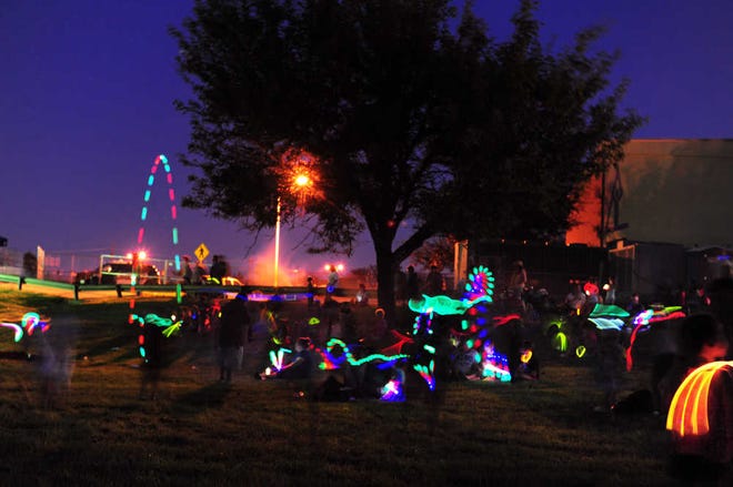Visitors play with light sticks in the twilight during the Discover 4.0 event Saturday, August 6, 2016 celebrating the 40th anniversary of the Don Harrington Discovery Center.
