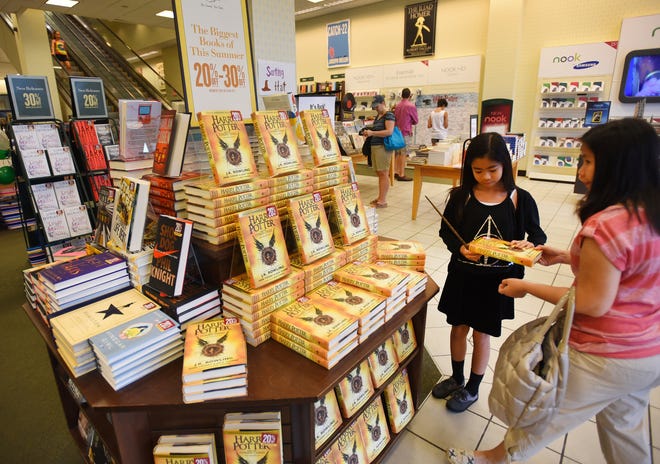 Allaine Lara, 10, of Westwood, N.J., picks up the latest book of Harry Potter with her mother Cecile at Barnes & Noble in The Shops at Riverside in Hackensack, N.J., Sunday, July 31, 2016. (Mitsu Yasukawa/The Record of Bergen County via AP)