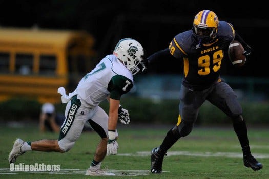Athens Christian's Richard Jibunor stiff arms Athens Academy's Owen Roberts after a catch during the first half of a game between Athens Academy and Athens Christian on Friday, Aug. 28, 2015, in Athens, Ga. (AJ Reynolds/Staff, @ajreynoldsphoto)