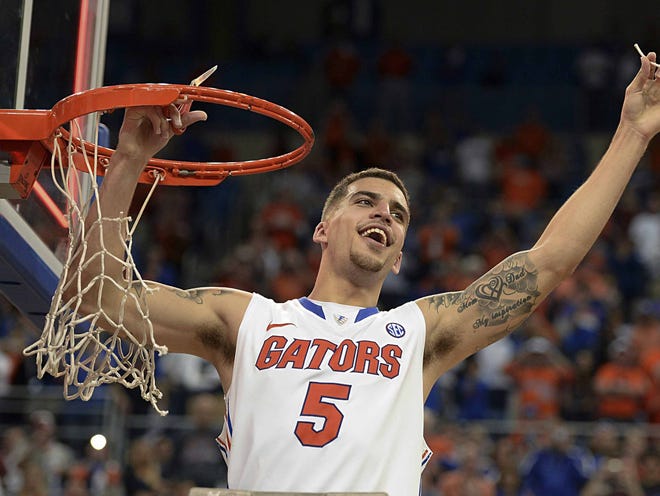 File photo - Florida guard Scottie Wilbekin (5) holds up a piece of the net after the Gators became the first team in Southeastern Conference history to go 18-0 in league pla, Saturday, March 8, 2014 in Gainesville, Fla. Florida defeated Kentucky 84-65 Saturday in an NCAA college basketball game.