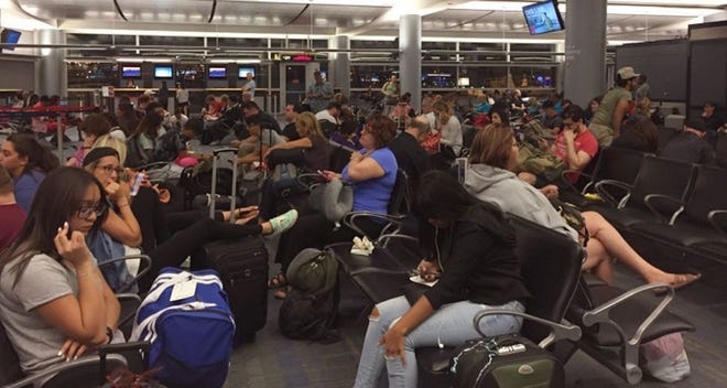 Passengers in the Delta Airlines boarding area at McCarran International Airport in Las Vegas are jammed in to wait as Delta Airlines says all its flights are grounded due to a system outage, Monday, Aug. 8, 2016. Delta Air Lines says it is has grounded flights after experiencing unspecified systems issues. (AP Photo/Bree Fowler)