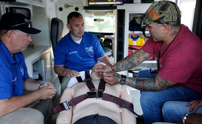 Derek Chiodi of Bridgewater administers a Narcan spray to the dummy with help from Paramedics from South Shore hospital Rich Kelly and Eugene Duffy during a Narcan training in East Bridgewater on Thursday, August 4, 2016.