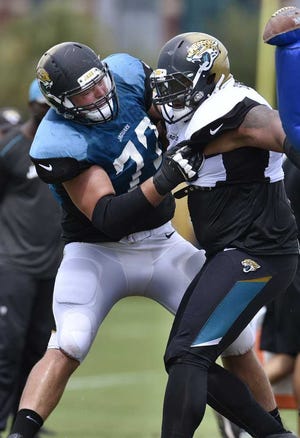 Will.Dickey@jacksonville.com--08/07/16--Jaguars offensive lineman Josh Wells (left) tangles with defensive tackle Michael Bennett during one-on-one drills at practice Sunday, August 7, 2016 at the EverBank Field practice fields in Jacksonville, Florida. (The Florida Times-Union, Will Dickey)