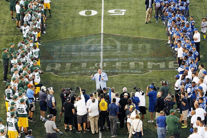 As the Green Bay Packers, left, and Indianapolis Colts, right, line the field Pro Football Hall of Fame President David Baker, center, announces that the preseason NFL football game between the Green Bay Packers and the Indianapolis Colts at Tom Benson Hall of Fame Stadium was cancelled due to unsafe field conditions caused by the painted logo at midfield Sunday in Canton, Ohio. AP PHOTO/GENE J. PUSKAR