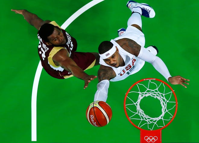 United States' Carmelo Anthony drives to the basket past Venezuela's Nestor Colmenares, left, during a basketball game at the 2016 Summer Olympics in Rio de Janeiro, Brazil, on Monday. JIM YOUNG / POOL PHOTO VIA AP
