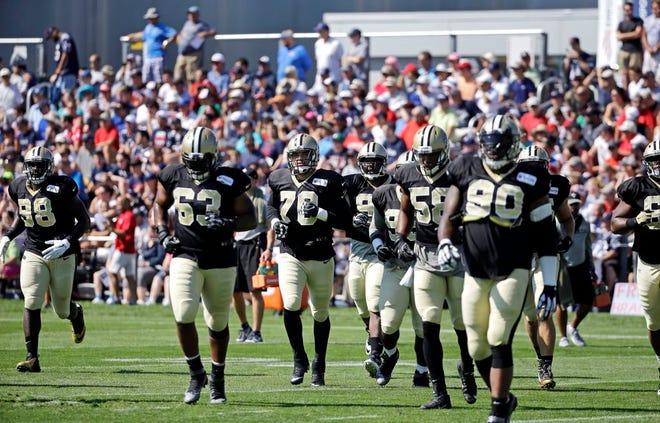 The Saints run onto the field for practice in Foxboro. The Associated Press