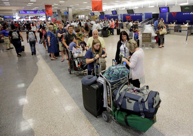 FILE - In this Tuesday, Aug. 9, 2016 file photo, Delta passengers stand in line as the carrier slogged through day two of its recovery from a global computer outage at Salt Lake City International Airport, in Salt Lake City. Delta fliers faced delays, cancelations and more headaches Wednesday as the Atlanta-based airline struggled with its computer systems for the third straight day. (AP Photo/Rick Bowmer)