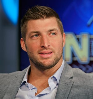 FILE - In this Aug. 6, 2014, file photo, Tim Tebow ponders a question during an interview on the set of ESPN's new SEC Network in Charlotte, N.C. With professional football not working out, Tebow is going to give baseball a try. The 2007 Heisman Trophy winner and former NFL first-round draft pick plans to hold a workout for Major League Baseball teams this month. Tebow last played organized baseball in high school. ESPN first reported the news. (AP Photo/Chuck Burton, File)