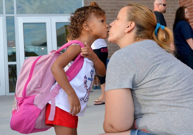 Cara, 3, gives her mother a quick kiss on the first day of school at Eustis Heights Elementary on Wednesday.