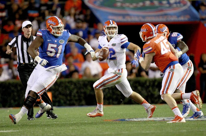 Florida offensive lineman Antonio Riles Jr. (51) leads the way for quarterback Austin Appleby during the Orange and Blue Debut spring game at Ben Hill Griffin Stadium in April. Riles suffered a knee injury in practice and is expected to miss the upcoming season. (Matt Stamey/The Gainesville Sun)