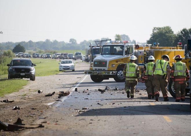 Boone County firefighters walk along the scene of a head on collision between a dump truck and a pickup truck on East Highway 124 just north of Hallsville on Thursday morning. The driver of the pickup was killed in the crash and the driver of the dump truck was taken to Boone Hospital Center for treatment.