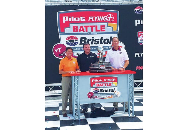 Bristol Motor Speedway Executive Vice President and General Manager Jerry Caldwell is flanked by University of Tennessee Vice Chancellor and Director of Athletics Dave Hart and Virginia Tech Athletic Director Whit Babcock at Wednesday''s press conference during which the "Pilot Flying J Battle at Bristol" trophy was displayed. (UT Athletics)