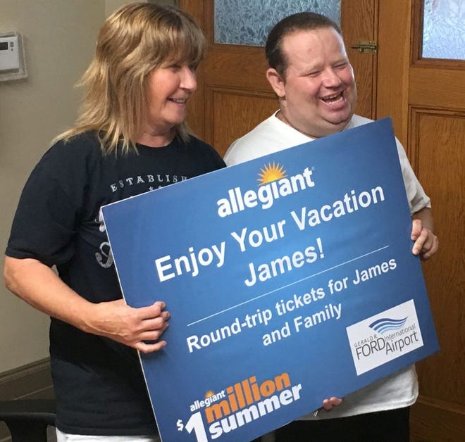 Marie Curler (left) and her son James Miller laugh Thursday at Belding City Hall after receiving round-trip tickets to Florida from Allegiant Air.