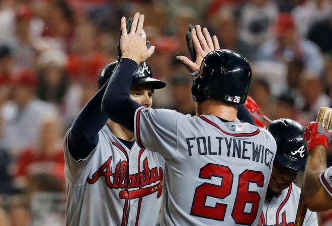 Atlanta Braves' Freddie Freeman, left, celebrates his three-run home run with starting pitcher Mike Foltynewicz (26) during the fifth inning of a baseball game against the Washington Nationals at Nationals Park, Friday, Aug. 12, 2016, in Washington. Foltynewicz hit a double, and was driven in by Freeman. (AP Photo/Alex Brandon)