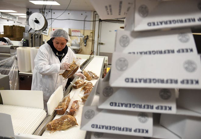 A worker prepares specialty meats for packaging in the Agostino Foods meat processing plant on Farragut Avenue in Bristol.