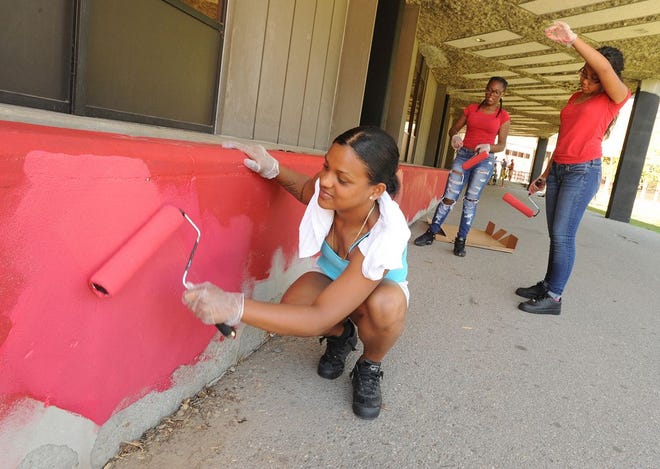 A soon-to-be Durfee junior, Christal Figueroa rolls on some paint that looks pink when wet but dries to a perfect Durfee red. behind her are Jakhia Calhou, left, who will be a sophomore come fall, and Jessica Rosario, who will be a junior.