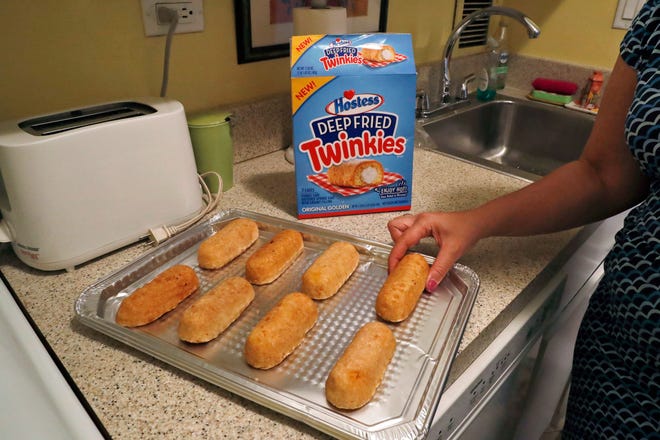 Associated Press reporter Anne D'Innocenzio arranges frozen, deep-fried Twinkies on a tray before baking in New York. The deep-fried Twinkie is jumping from the state fair to an oven near you. Hostess is launching packaged "Deep Fried Twinkies" that mark its first foray into frozen foods. (AP Photo/Mary Altaffer)