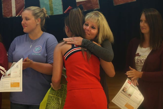 Ashlyn Aleywine hugs her former kindergarten teacher Mary Taylor after giving her a bag of supplies for her classroom. Taylor is one of 11 teachers whose classrooms were vandalized at Deane Bozeman School in July.